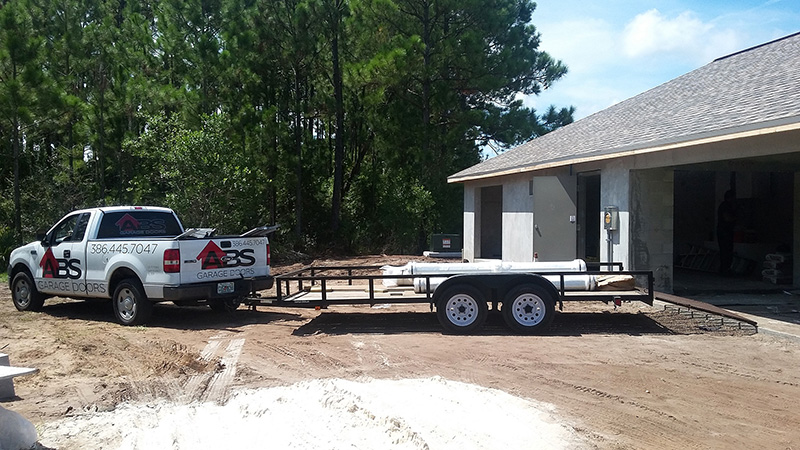 abs truck with trailer in driveway of home