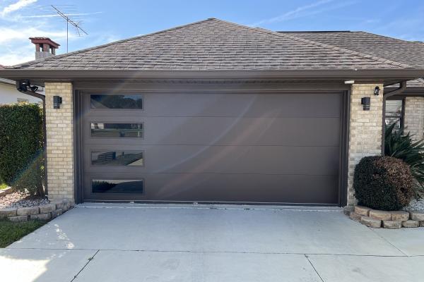 Customer recently purchased a home and was in the process of giving it a makeover. To give the front of their home a more modern look they chose the CHI Skyline Flush Series garage door with long panel tinted glass.