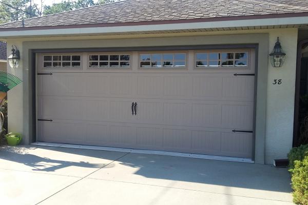 Carriage house stamped garage door with hardware bringing life to an older home.