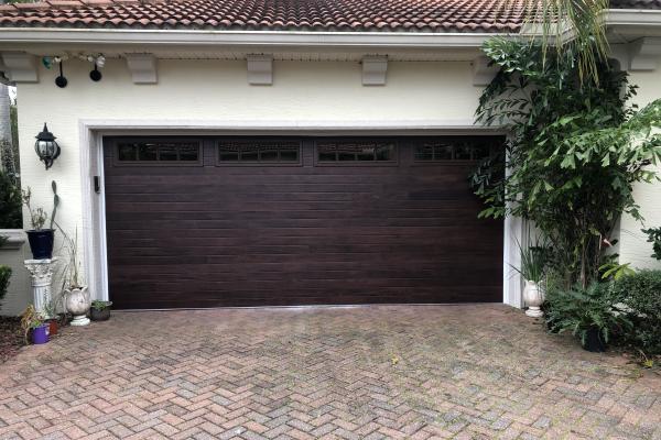Homeowner wanted to update the look of their home and chose a CHI Accents Planks garage door in mahogany with madison glass design. 