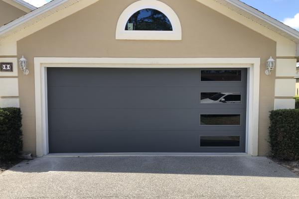 Homeowners are completely renovating their house and chose a CHI Skyline Garage Door in Graphite with Vertical Stacked Tinted Windows. 