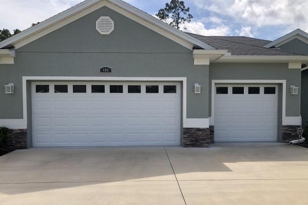 Raised panel garage doors with plain glass installed on a new home.