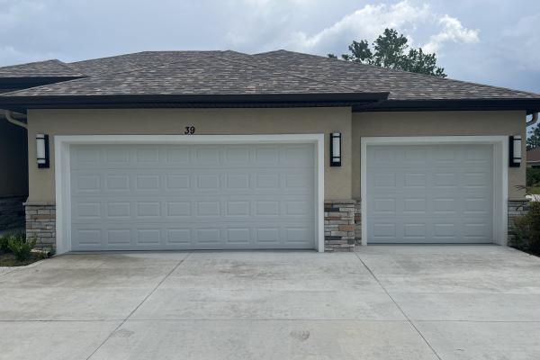 New build home with two raised short panel garage doors.