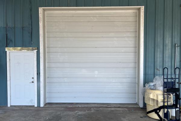 New commercial ribbed garage door installed in existing building.