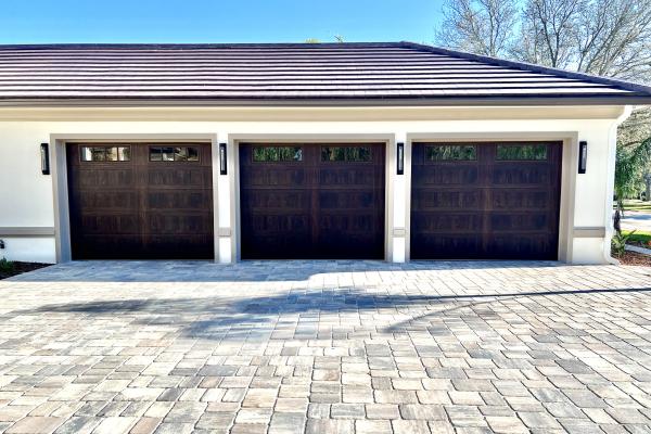 Recently constructed home with Accents series Stamped Shaker Garage doors in Walnut with Madison Glass Top Section.