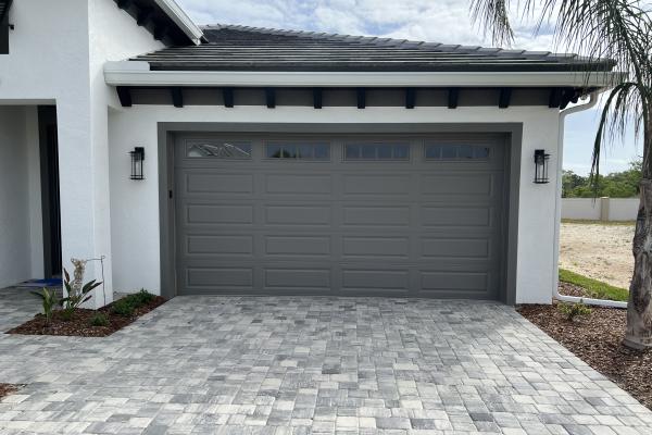 Newly constructed home with a Raised Long Panel Garage Door and Glass Top Section Ached Madison Design.