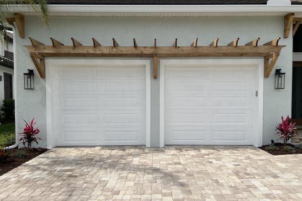 Recently constructed home with raised long panel garage doors. 
