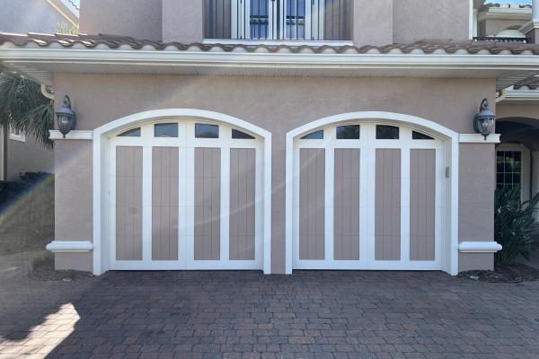 Custom built home with hand made carriage house style garage doors and arched glass top sections. Garage door colors were created by homeowner.
