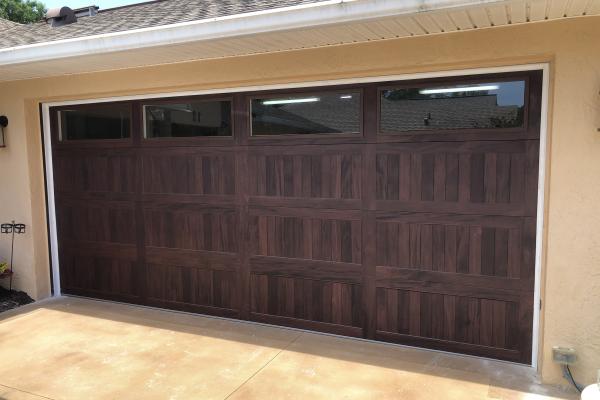 Customer was remodeling their home and wanted a wood look door without the problems associated with wood garage doors. They went with a carriage stamp door with long panel glass windows in mahogany color.