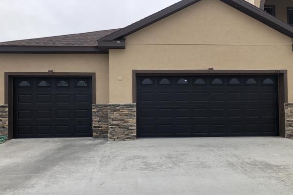 Raised Short Panel Garage Door in Black with Glass Top Section Cathedral Inserts.